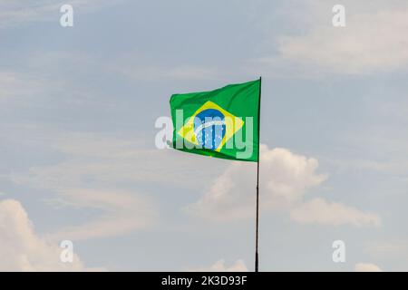 Goias, Brésil – 25 septembre 2022 : drapeau du Brésil volant et flottant dans le vent avec ciel nuageux en arrière-plan. Banque D'Images