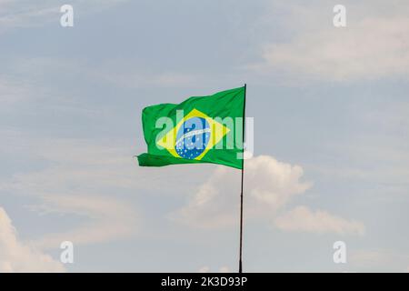 Goias, Brésil – 25 septembre 2022 : drapeau du Brésil volant et flottant dans le vent avec ciel nuageux en arrière-plan. Banque D'Images