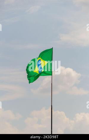 Goias, Brésil – 25 septembre 2022 : drapeau du Brésil volant et flottant dans le vent avec ciel nuageux en arrière-plan. Banque D'Images