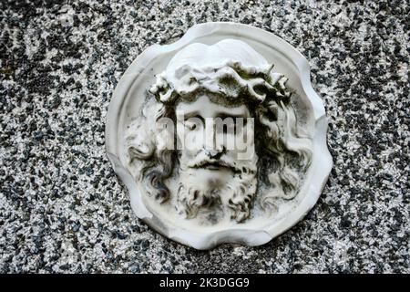 Vieux portrait sculptural éraflé du visage d'un homme barbu avec couronne d'épines, censé représenter Jésus-Christ. Banque D'Images