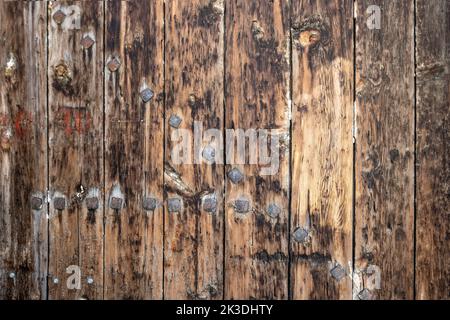 Un vieux bois brun, non peint, naturel avec des grains et de gros clous en fer pour le fond et la texture. Photo de haute qualité Banque D'Images