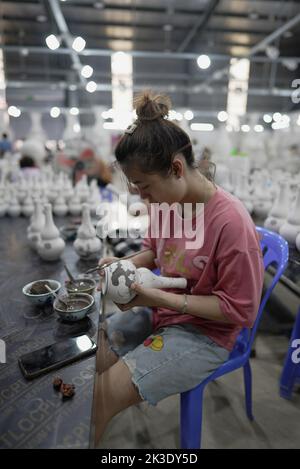 Vietnam, près de Hanoï, céramiste peignant un vase dans une usine de céramique dans le village de céramique de Bat Trang. Banque D'Images