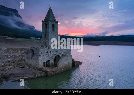 Clocher de Sau entièrement exposé pendant la sécheresse de 2022. Lever de soleil rouge dans le marais (Osona, Barcelone, Catalogne, Espagne) ESP: Campanario de Sau Banque D'Images