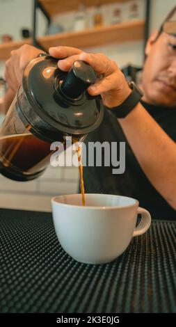 Versez du café fraîchement préparé à l'aide d'une cafetière à piston Banque D'Images