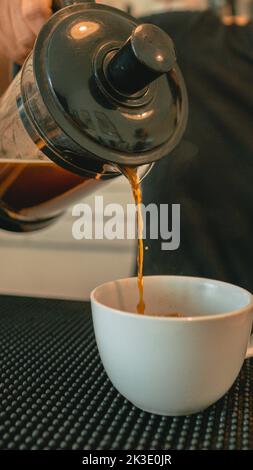 Versez du café fraîchement préparé à l'aide d'une cafetière à piston Banque D'Images