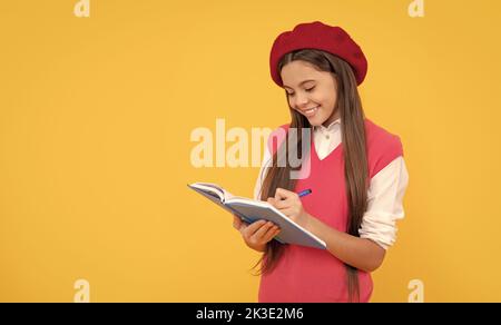 bonne fille d'école d'adolescence en béret français faire des notes dans le bloc-notes de planificateur ou bloc-notes, la connaissance Banque D'Images