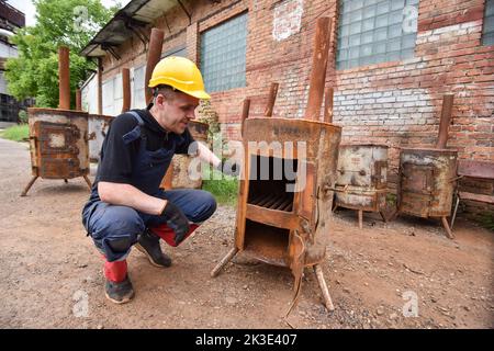 Lviv, Ukraine. 2nd septembre 2022. Un homme regarde un poêle en métal spécial prêt à l'emploi pour chauffer les sous-sols de maisons et d'abris, qui sera installé à Lviv en raison de l'invasion militaire russe de l'Ukraine. Les entreprises communautaires Lviv fabriquent des poêles métalliques spéciaux qui peuvent être utilisés pour chauffer des abris et des sous-sols de maisons. En raison de la menace de destruction des infrastructures critiques par les bombes russes, Lviv pourrait être sans chauffage en hiver. Ces poêles sont faits pour fournir aux gens de la chaleur. Pour obtenir la chaleur d'eux, vous devez brûler le bois dans eux. La ville prévoit de fabriquer et d'installer environ Banque D'Images