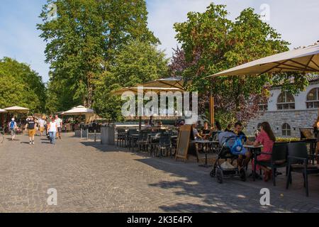 Ljubljana, Slovénie - 3 septembre 2022. Une route piétonne animée avec des bars et des restaurants sur le front de mer de la rivière Ljubljana Banque D'Images