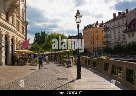 Ljubljana, Slovénie - 3 septembre 2022. Une route piétonne animée avec des bars et des restaurants sur le front de mer de la rivière Ljubljana Banque D'Images