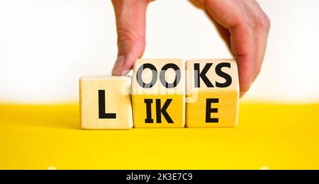 Ressemble à un symbole. Les mots concept ressemblent à des cubes en bois. Main d'homme d'affaires. Magnifique table jaune fond blanc. Affaires, citations populaires et l Banque D'Images