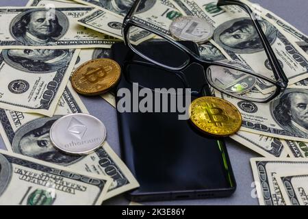 Lunettes, smartphone avec tableaux financiers, portefeuille, crypto-pièces, horloge orange couchée Banque D'Images