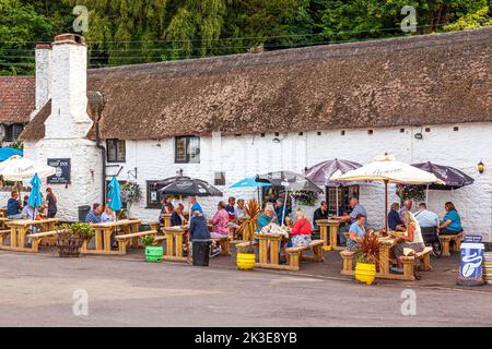 Dînez et buvez en plein air au Ship Inn lors d'une soirée d'été près du port sur la côte nord d'Exmoor à Porlock Weir, Somerset, Royaume-Uni Banque D'Images