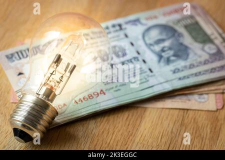 Argent indien beaucoup de roupies et une ampoule, concept de la hausse des prix de l'énergie et de l'électricité en Inde Banque D'Images