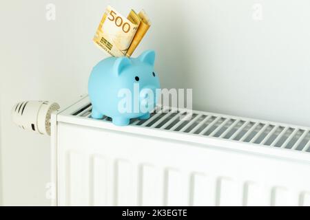 500 billet de Kroner norvégien sortant d'une banque de porc debout sur un radiateur, le concept de la hausse des prix de l'énergie en Norvège et plus cher il Banque D'Images