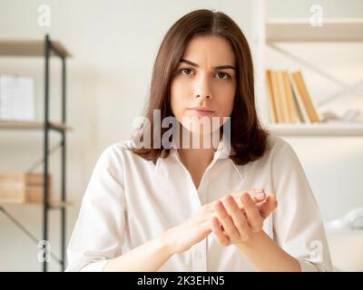 Leçon en ligne. Travail incorrect. Vidéoconférence. Enseignant strict. Une femme sceptique se clamant les mains en regardant la caméra maison lieu de travail intérieur backgroun Banque D'Images