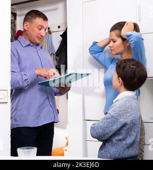 Femme et fils frustrés parlant à la dette collectrice Banque D'Images