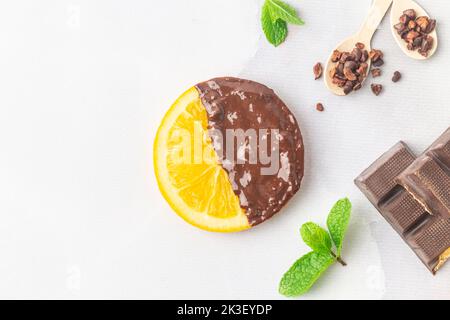 Faire des tranches d'orange confites enrobées de chocolat noir Banque D'Images