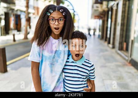 Famille afro-américaine de la peine et de la sœur debout dans la rue effrayée et stupéfait avec la bouche ouverte pour la surprise, visage incrédulé Banque D'Images