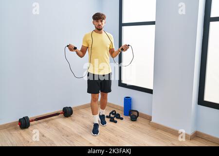 Homme arabe avec la formation de la barbe avec corde de saut sceptique et nerveux, frowning bouleversé à cause du problème. Personne négative. Banque D'Images