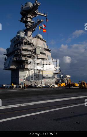 L'ombre d'un MH-60s Nighthawk attaché aux 'Tridents' de l'Escadron de combat en mer (HSC) 9 est moulée sur l'île du premier porte-avions de classe USS Gerald R. Ford (CVN 78) pendant une charge de munitions, le 25 septembre 2022. Ford est en cours dans l'océan Atlantique en vue d'un déploiement prévu cet automne. (É.-U. Photo de la marine par William Spears, spécialiste des communications de masse, classe 1st) Banque D'Images