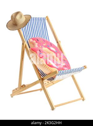 Chaise longue, chapeau et anneau gonflable sur fond blanc Banque D'Images