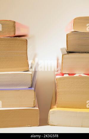 Deux piles de livres de poche sur fond blanc. Banque D'Images