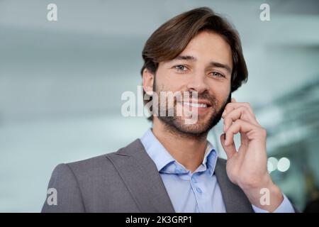 Contacter ses clients. Un beau jeune homme d'affaires communiquant par téléphone portable. Banque D'Images