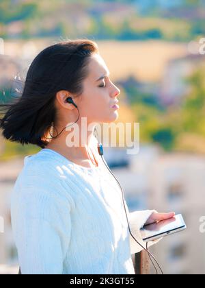 Perdu dans la musique. Une jeune femme attrayante écoutant de la musique sur sa tablette. Banque D'Images