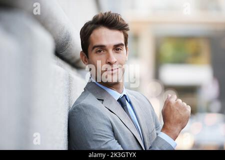 Travailler en ville. Un beau jeune homme d'affaires regardant la caméra. Banque D'Images