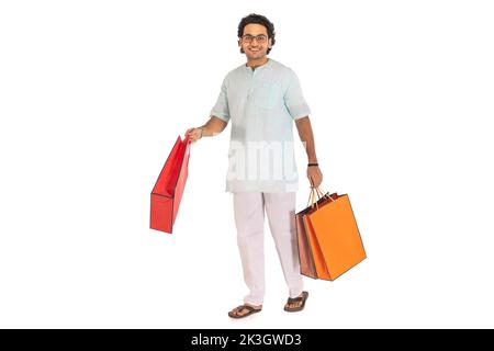 Portrait d'un homme bengali portant des sacs de shopping sur fond blanc Banque D'Images
