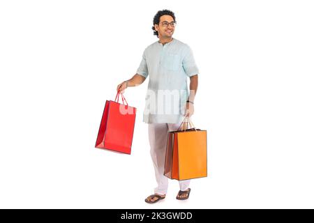 Portrait d'un homme bengali portant des sacs de shopping sur fond blanc Banque D'Images