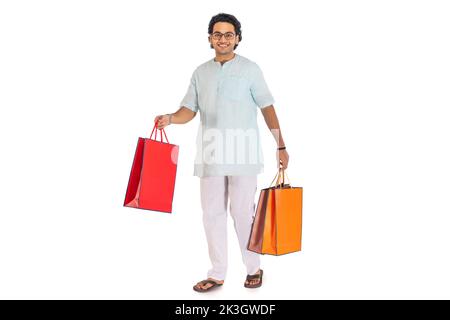 Portrait d'un homme bengali portant des sacs de shopping sur fond blanc Banque D'Images