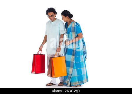 Couple bengali heureux debout avec des sacs de shopping Banque D'Images