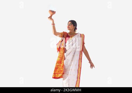 Portrait d'une femme bengali qui exécute la danse Dhunuchi sur fond blanc Banque D'Images