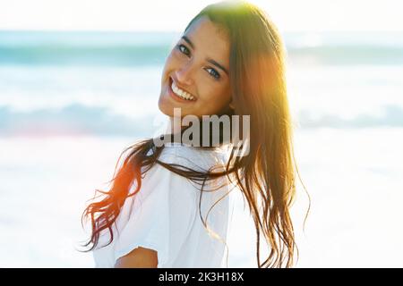 Embrasser l'esprit de l'été. Jolie femme debout à l'extérieur et souriant à l'appareil photo. Banque D'Images