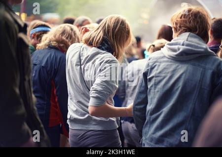 Adoring audience. Vue arrière d'une foule dansant lors d'un événement musical en plein air. Banque D'Images