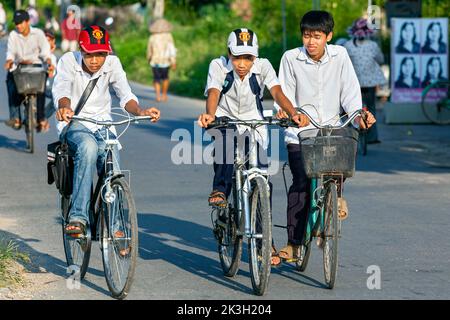 Étudiants vietnamiens à vélo sur route rurale, Hai Phong, Vietnam Banque D'Images