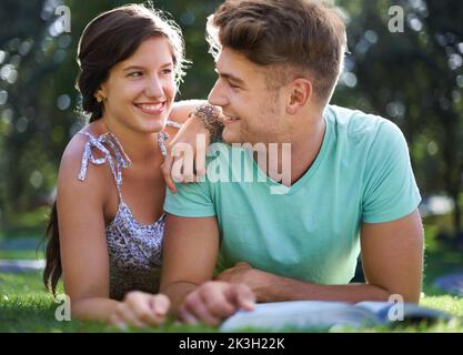 Ils font tout ensemble, y compris étudier. Un jeune couple à l'université étudiant ensemble dans le parc. Banque D'Images