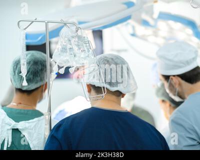 Moscou. Russie. 22 septembre 2022. Accent sélectif sur les sachets en plastique transparent de compte-gouttes médicaux dans la salle d'opération. Chirurgiens sur fond flou. Banque D'Images