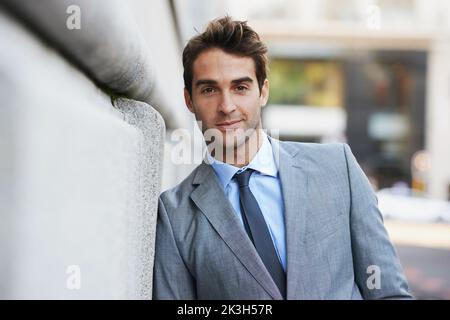 Travailler en ville. Un beau jeune homme d'affaires regardant la caméra. Banque D'Images