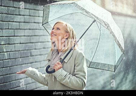 Son bonheur pleurant. Une jeune femme attrayante marchant sous la pluie. Banque D'Images