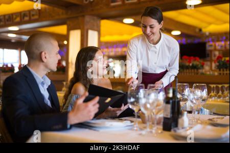 Femme serveur prend la commande des clients dans restaurante Banque D'Images