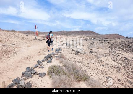 Jeune femme randonnée le long des falaises et des plages préservées sur l'île de la Graciosa, aux îles Canaries. Banque D'Images