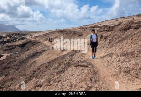 Jeune femme randonnée le long des falaises et des plages préservées sur l'île de la Graciosa, aux îles Canaries. Banque D'Images