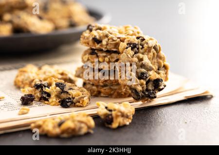 Biscuits d'avoine. Petits gâteaux avec flocons d'avoine et raisins secs sur les journaux. Banque D'Images