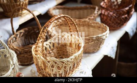 Magnifique panier en osier sur la table. Paniers de pique-nique et de transport de nourriture texturés bruns. Banque D'Images