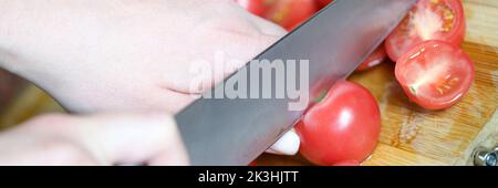 Chef coupe des tomates dans la cuisine et le végétarisme Banque D'Images