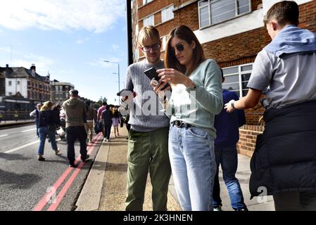 Londres, Angleterre, Royaume-Uni. Couple regardant leurs téléphones mobiles Banque D'Images