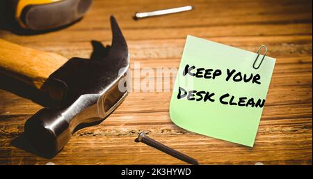 Composite de pense-bête avec garder votre bureau propre texte avec un marteau et des clous sur la table en bois Banque D'Images