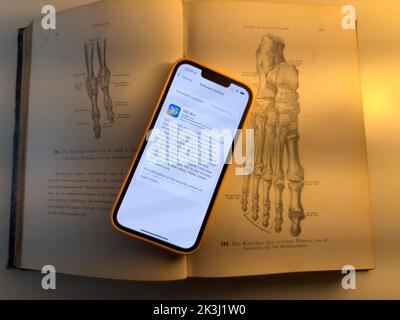 Paris, France - 17 septembre 2022: Mise à jour d'Apple Computers iphone 13 Pro processus de mise à jour vers le nouveau système d'exploitation iOS 16 - téléphone placé au-dessus de l'ancien livre d'anatomie Banque D'Images